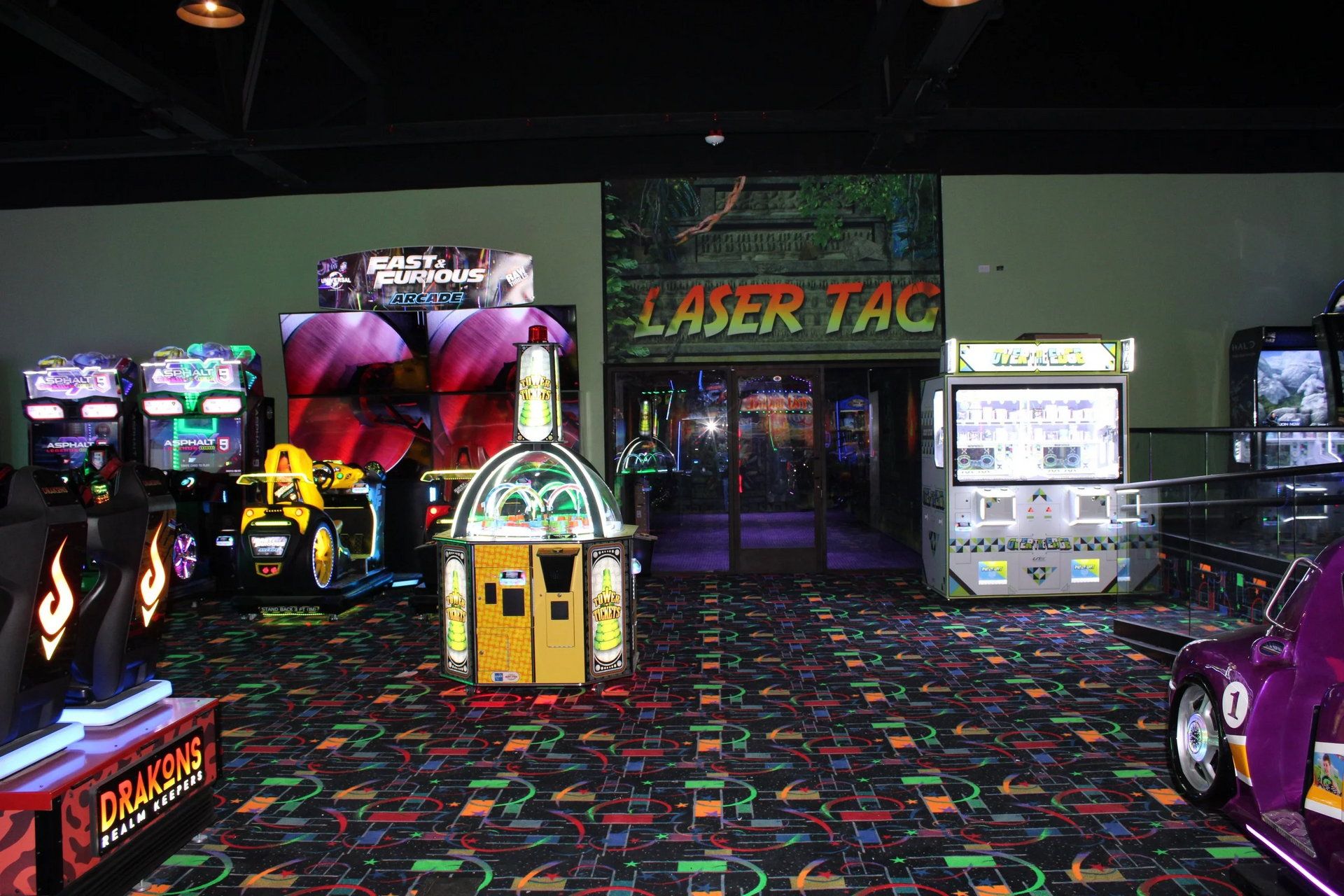 Arcade with Laser Tag entrance, multiple game machines, and colorful carpet.