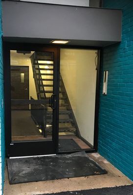 Exterior door with glass panels and a staircase visible inside.