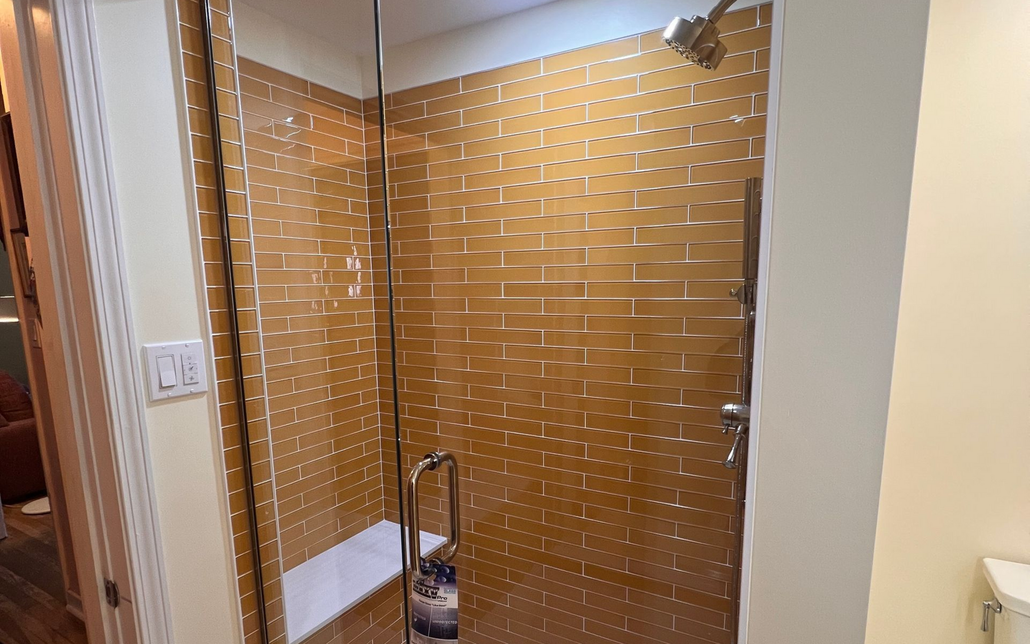 Modern white bathroom featuring a walk-in glass shower next to a freestanding soaking tub under a window.
