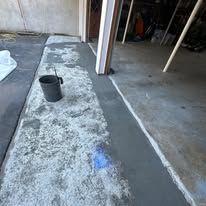 A bucket is sitting on the ground in a garage.