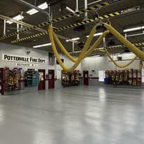 A fire station with a lot of hoses hanging from the ceiling.
