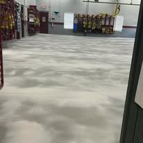 A large room with a concrete floor and a lot of boxes on the floor.