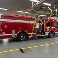 A red fire truck is parked in a garage.