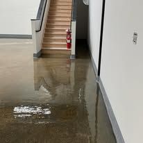 A hallway with stairs and a fire extinguisher on the wall.