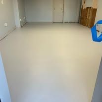 A room with a white floor and a blue tape on the floor.