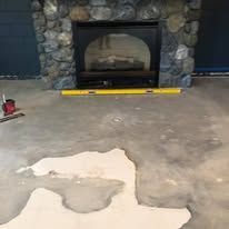 A fireplace in a living room with a yellow level on the floor.