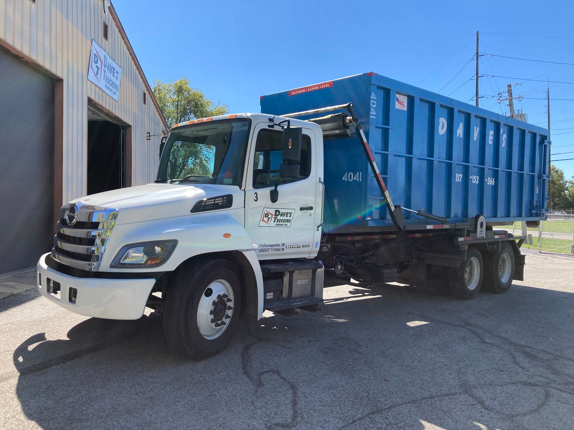 A dump truck is parked in front of a building.