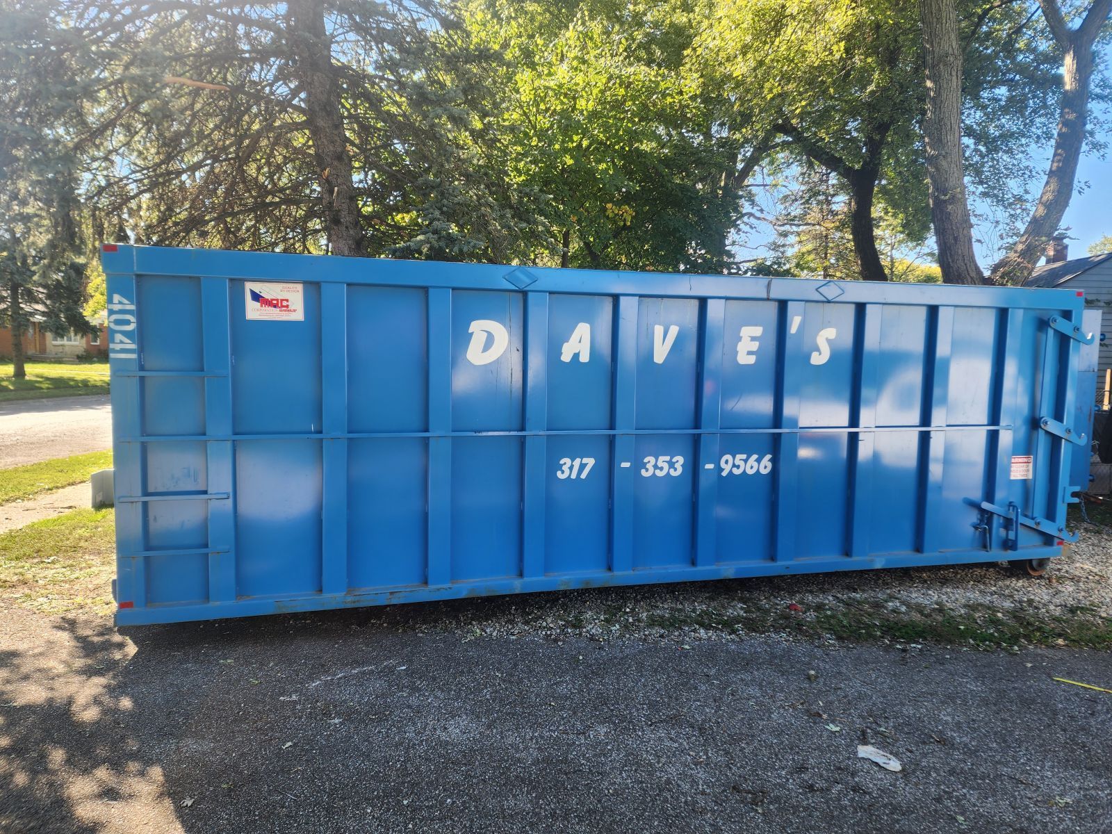 A blue dumpster with daves written on it
