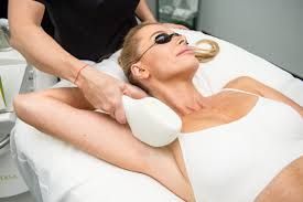 Woman receiving laser hair removal treatment on her underarm; in a medical setting.