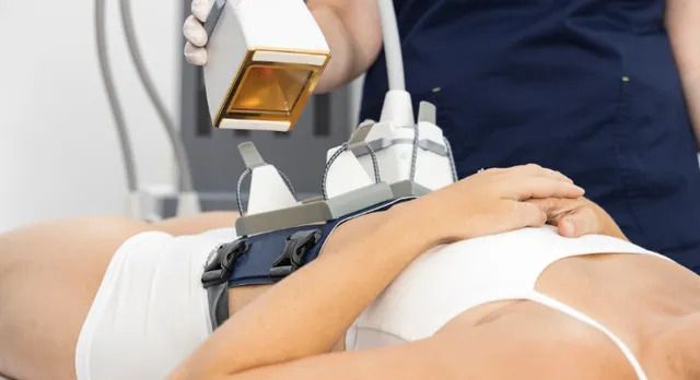 Woman undergoing body contouring treatment on stomach with a laser and applicators.