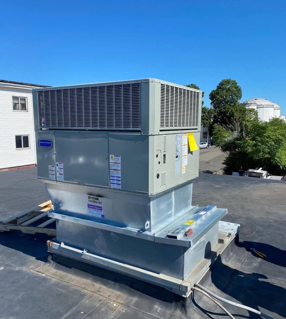 Large rooftop HVAC unit on a flat roof under a clear blue sky