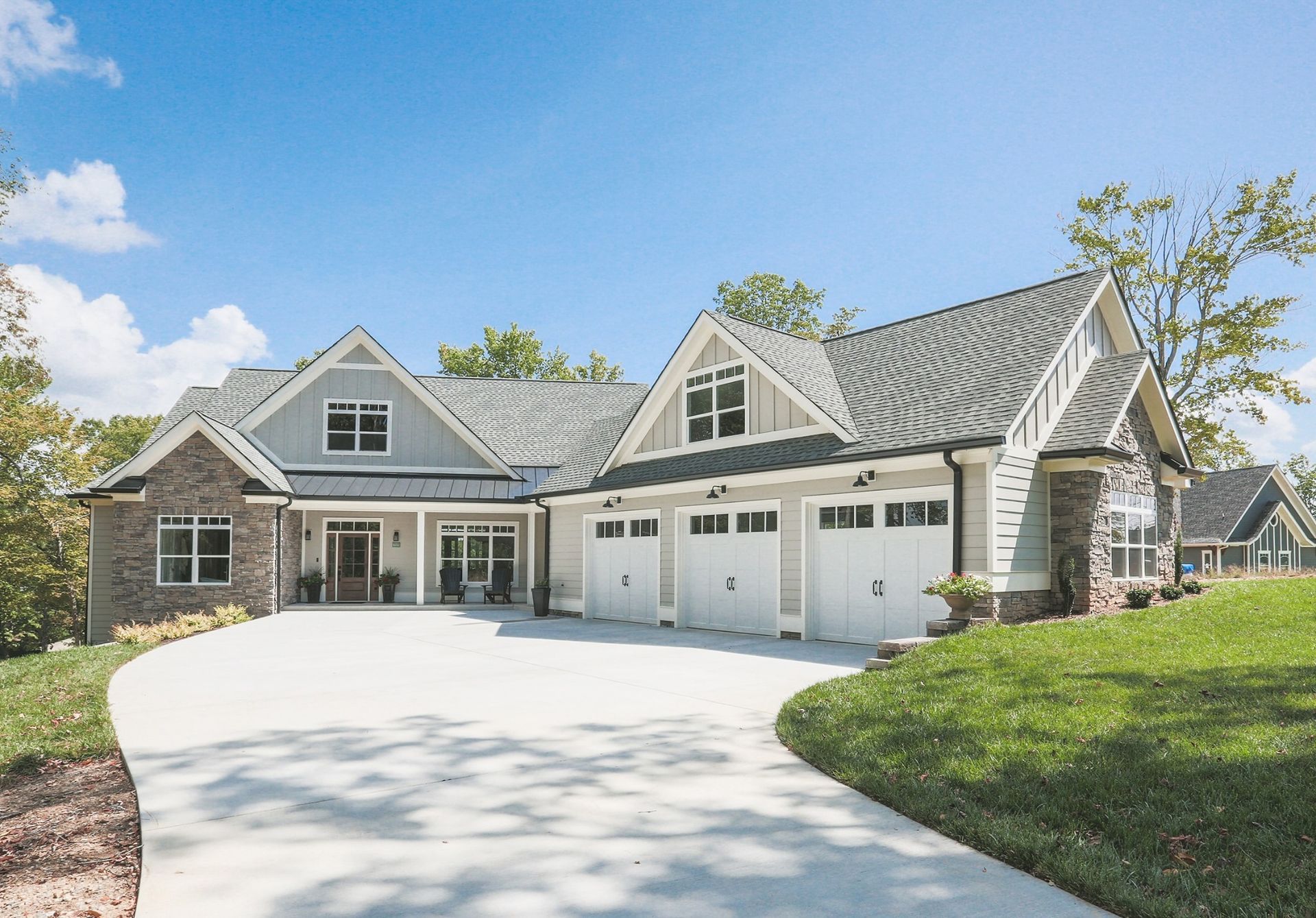 A large house with a lot of garage doors and a driveway leading to it.