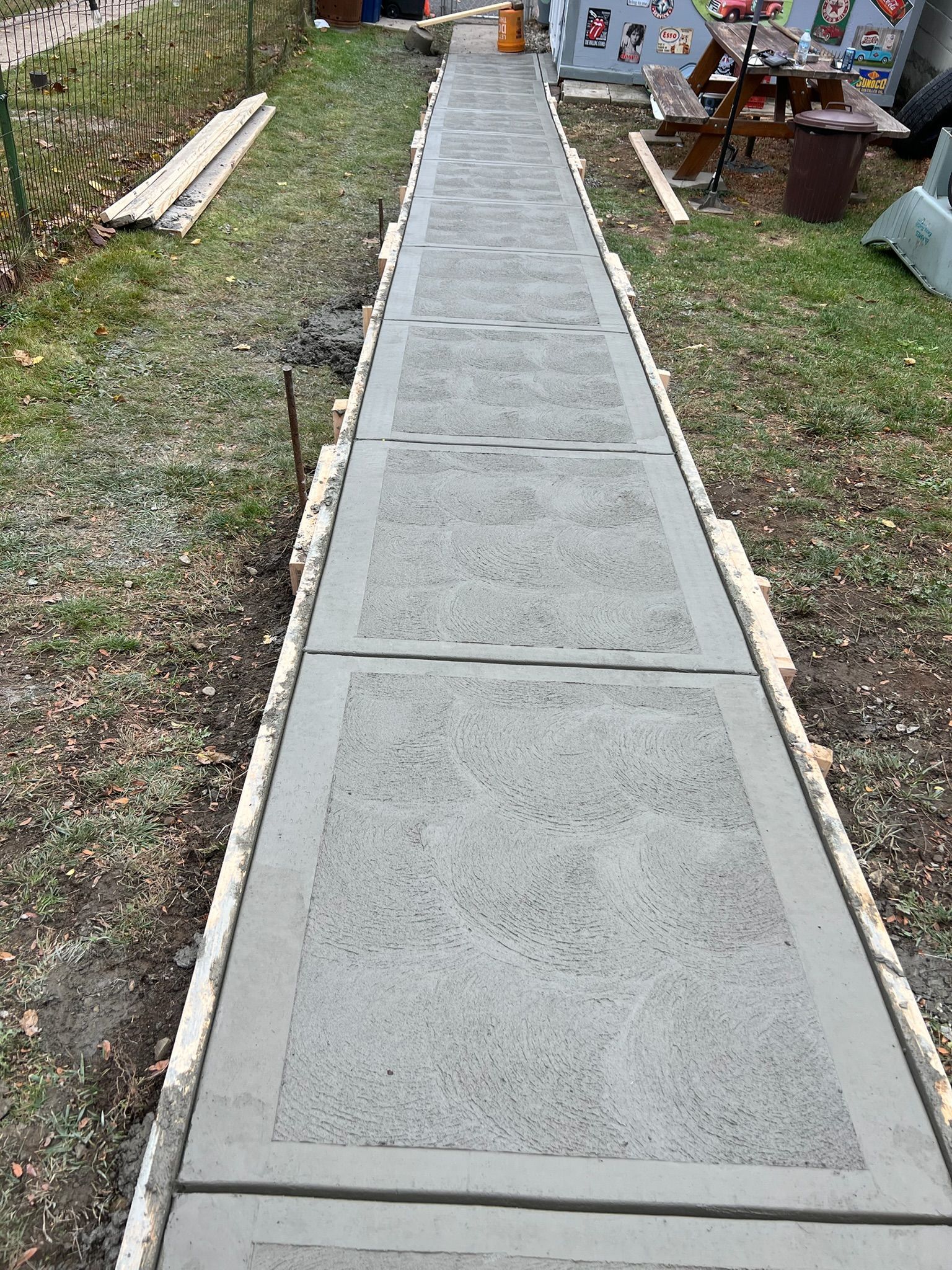 Concrete walkway leading through a grassy yard to a house entrance