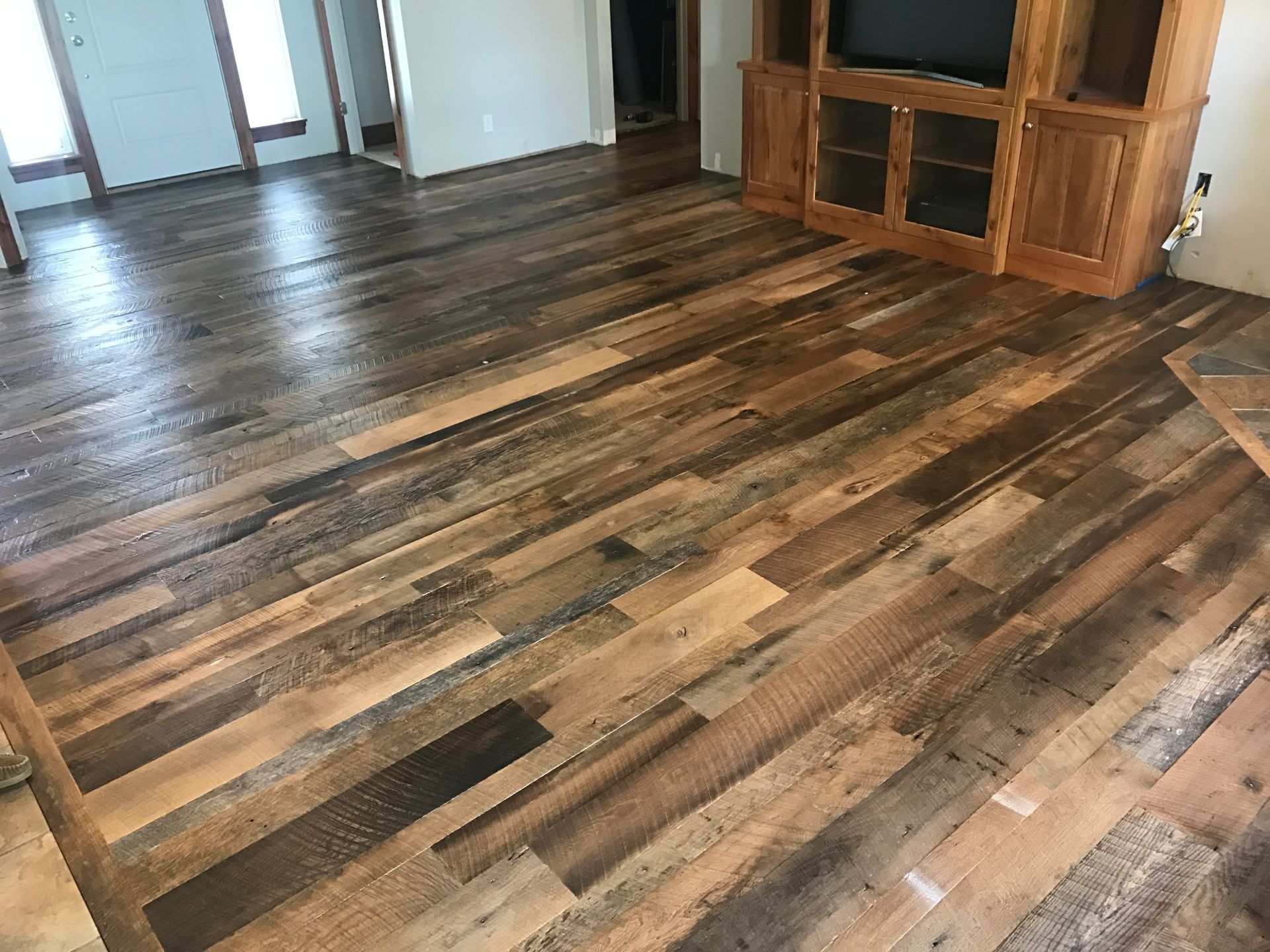 a living room with a wooden floor and a tv stand.