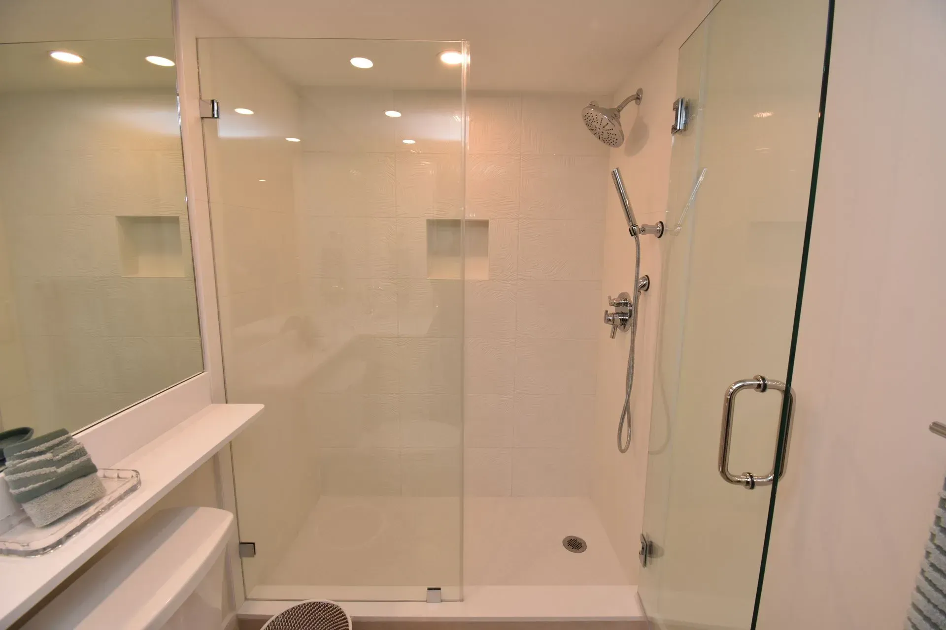 Bathroom with a glass-enclosed shower, white walls, and a toilet.