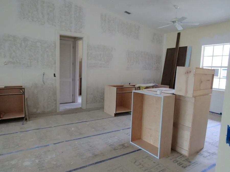Kitchen under renovation, with unfinished cabinets and drywall.