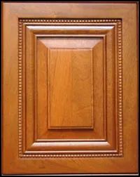 Wooden cabinet door with raised panel and decorative beading, finished in a warm brown.