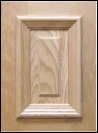 Wooden cabinet door with recessed panel, light brown finish.