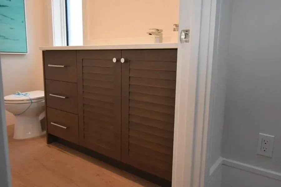 Bathroom with a brown vanity, white countertop, and a toilet.