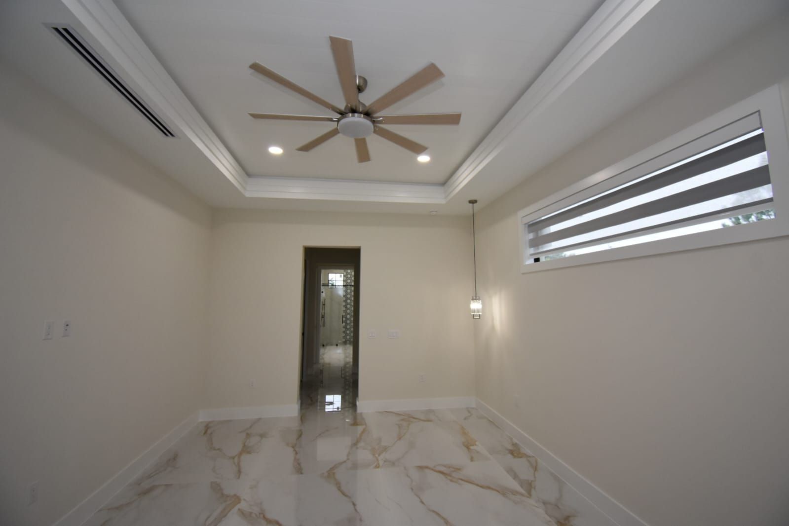 Empty room with marble floor, ceiling fan, recessed lighting, and window with blinds.