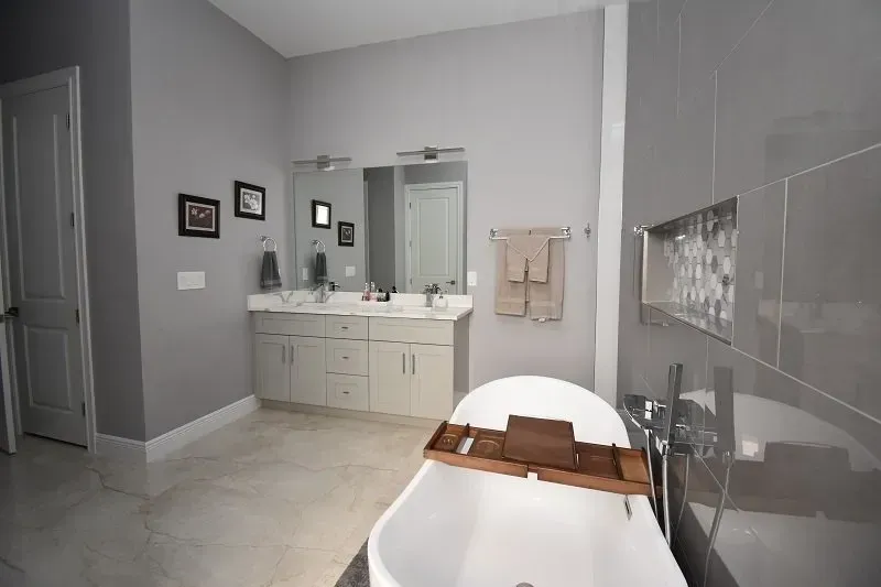 Gray bathroom with a soaking tub and double vanity.