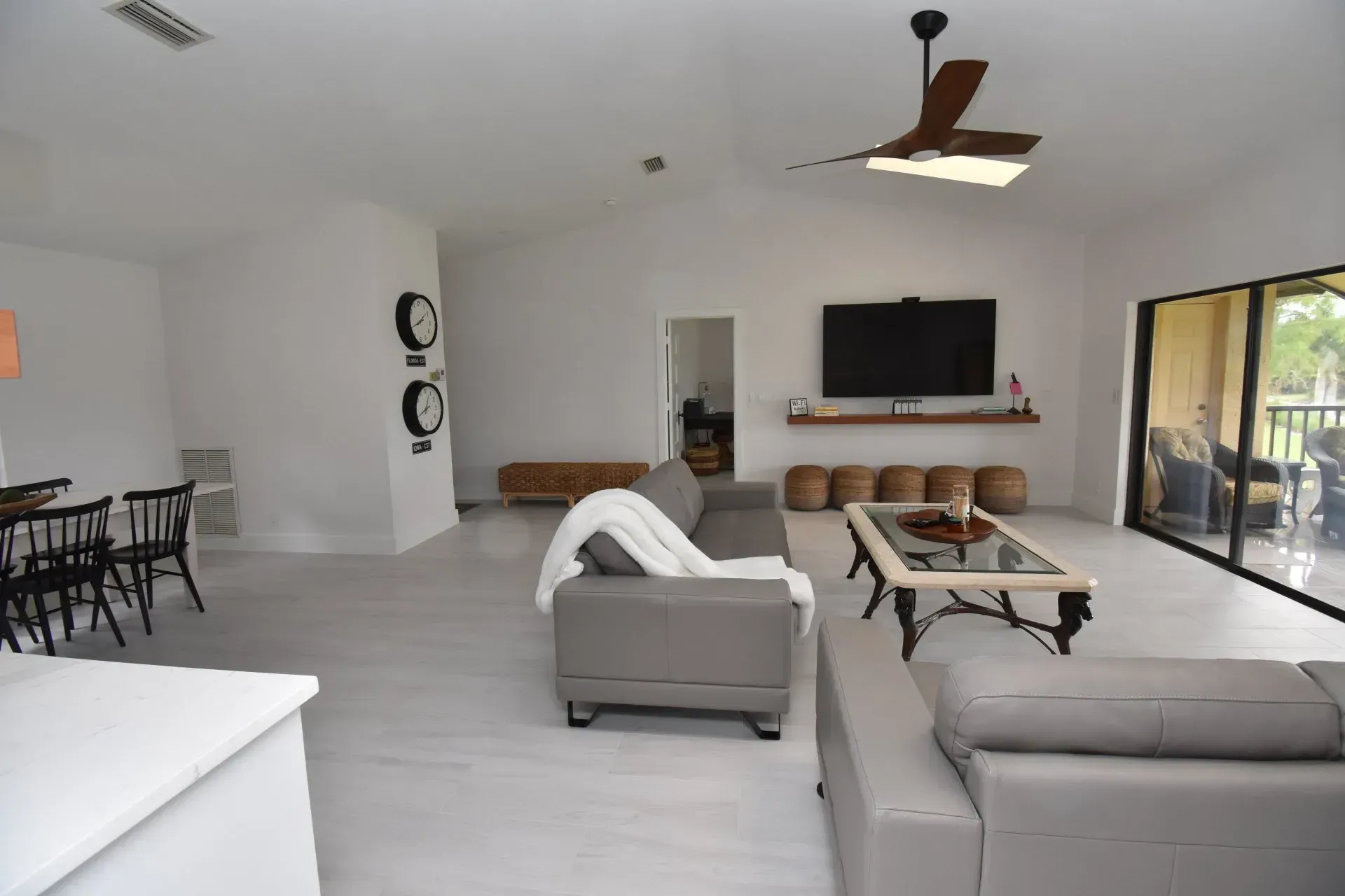 Spacious living room with gray furniture, TV, and sliding glass doors. 