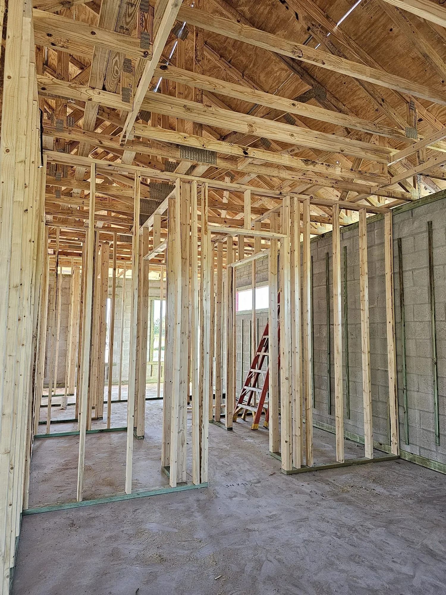 Interior view of a building under construction, showcasing wooden framing for walls and ceiling.