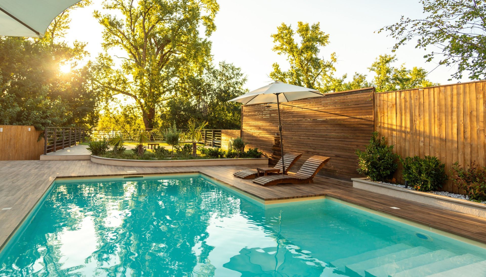 A rectangular inground swimming pool in a backyard on a sunny day.