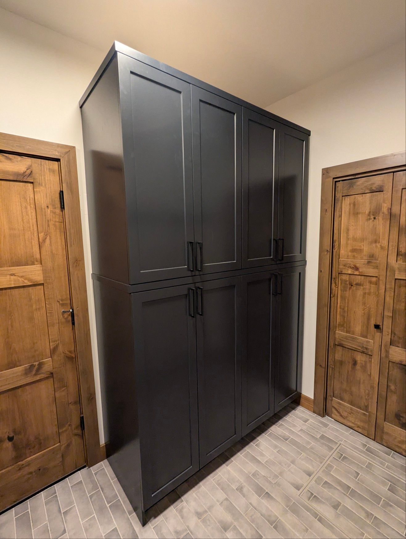 A room with a large black cabinet and wooden doors