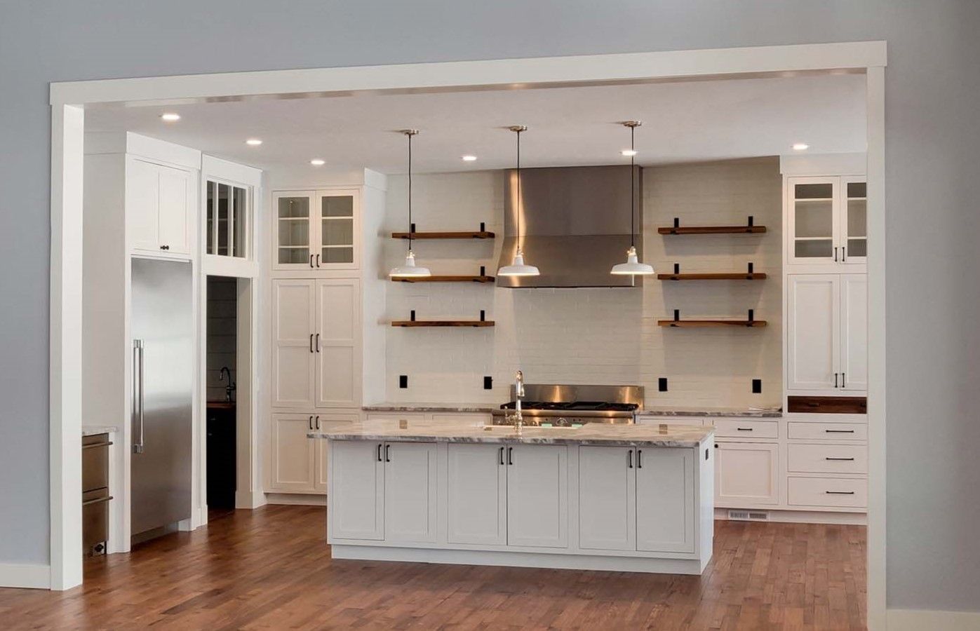 A kitchen with white cabinets and stainless steel appliances