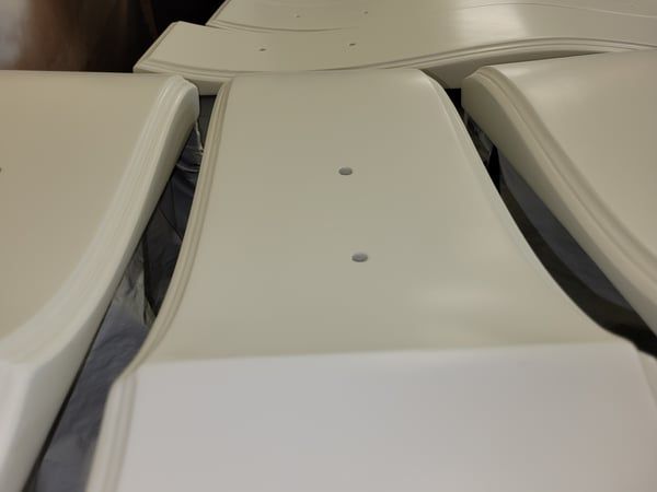 A bunch of white chairs are stacked on top of each other