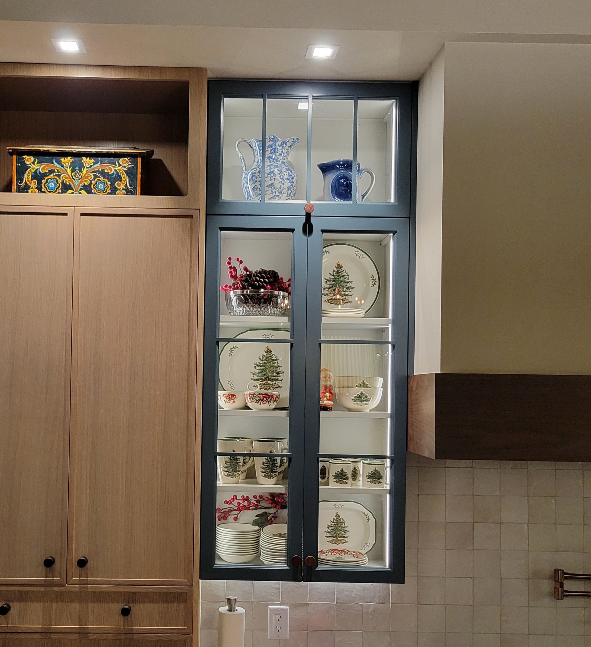 A kitchen with a glass door filled with plates and cups