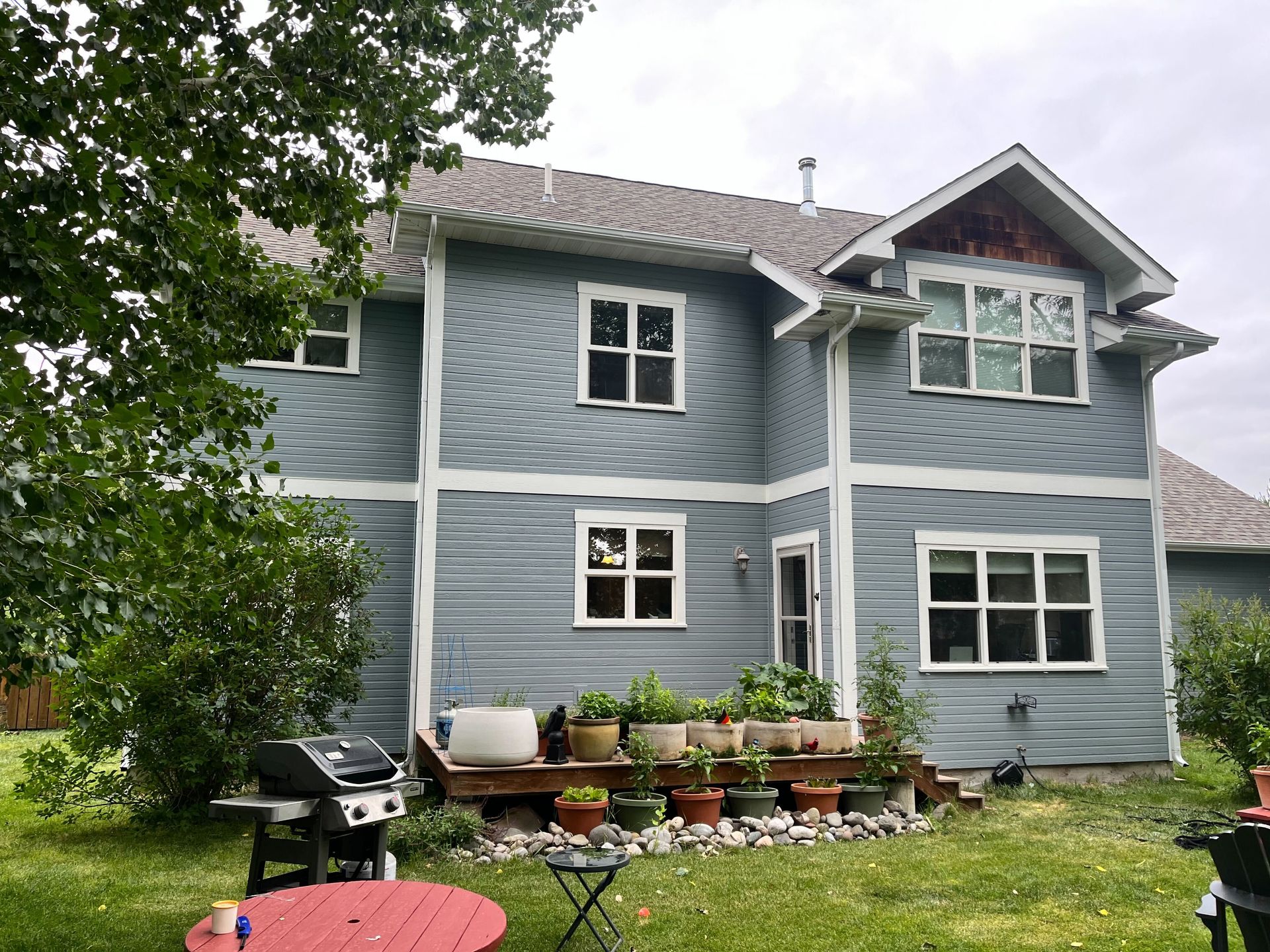 A large blue house with a red table and chairs in front of it