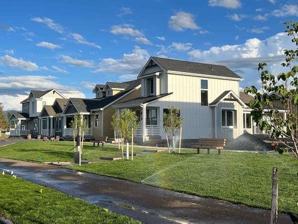 A row of houses with sprinklers in front of them