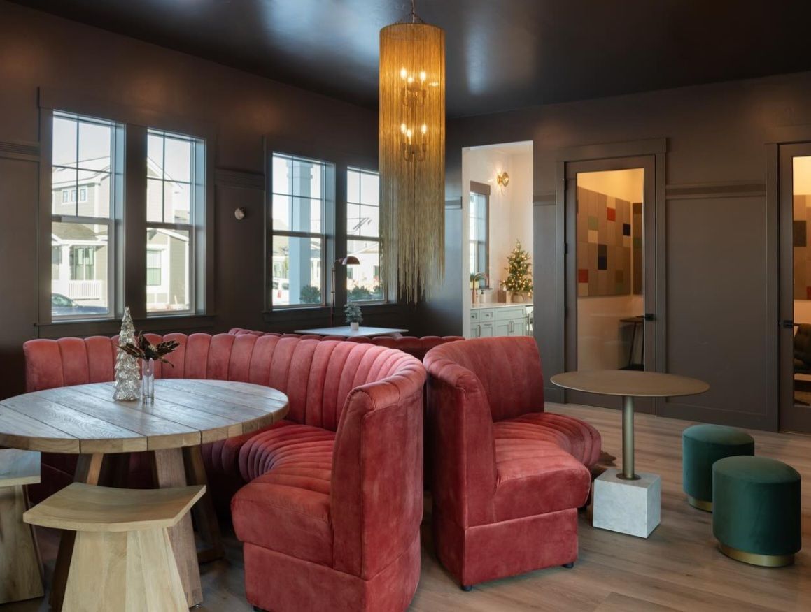 A living room with a couch , tables , chairs and a chandelier.