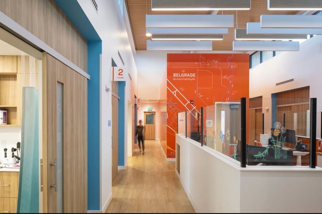 An artist's impression of a hospital hallway with a woman sitting at a desk.