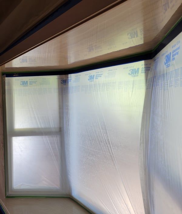 A room with a window and a wall covered in plastic.