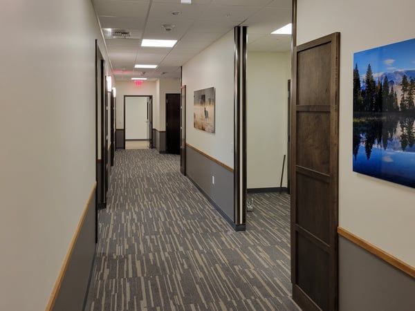 A hallway with a picture of a lake on the wall