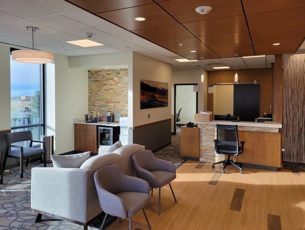 A waiting room with a couch and chairs and a counter