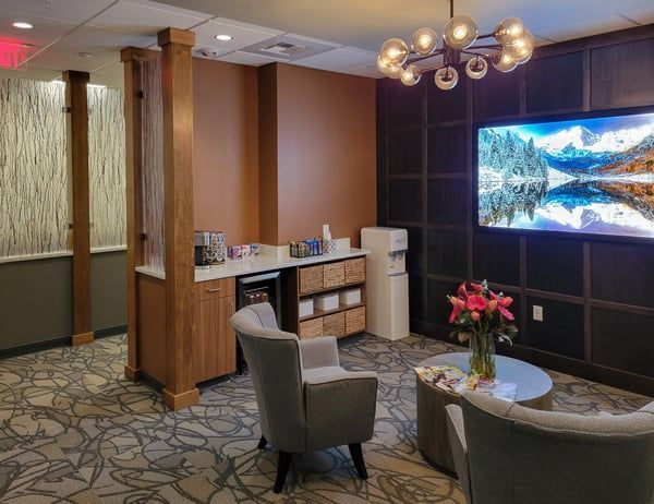 A living room with chairs , a table and a television.