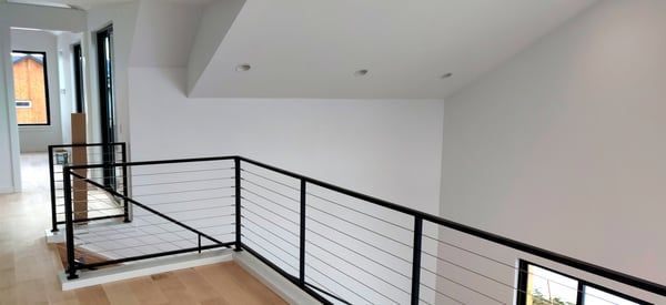 A staircase with a black railing and a wooden floor in a house.