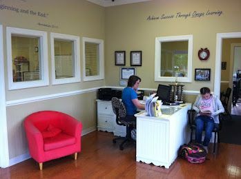 A woman is sitting at a desk in a waiting room.