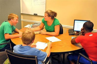 A group of people are sitting around a table with papers on it