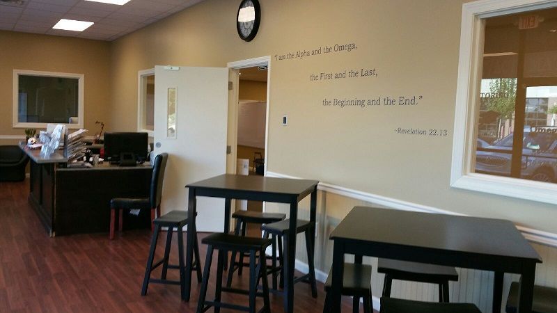 A room with tables and chairs and a clock on the wall