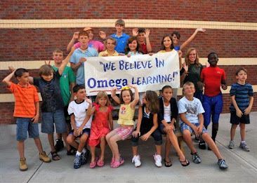 A group of children holding a sign that says we believe in omega learning