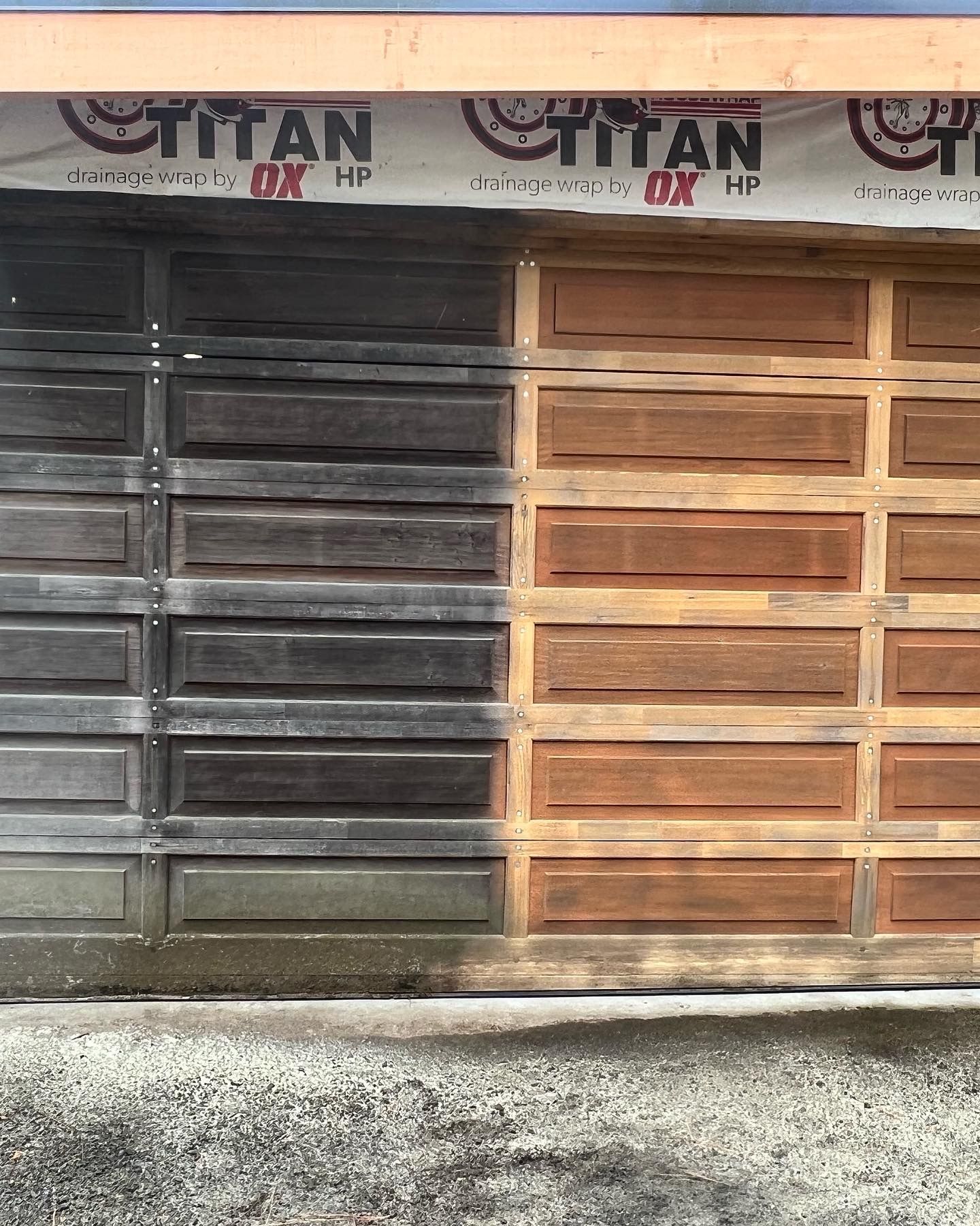 Garage door, half cleaned. Left side is dark, dirty. Right side is light brown, clean.