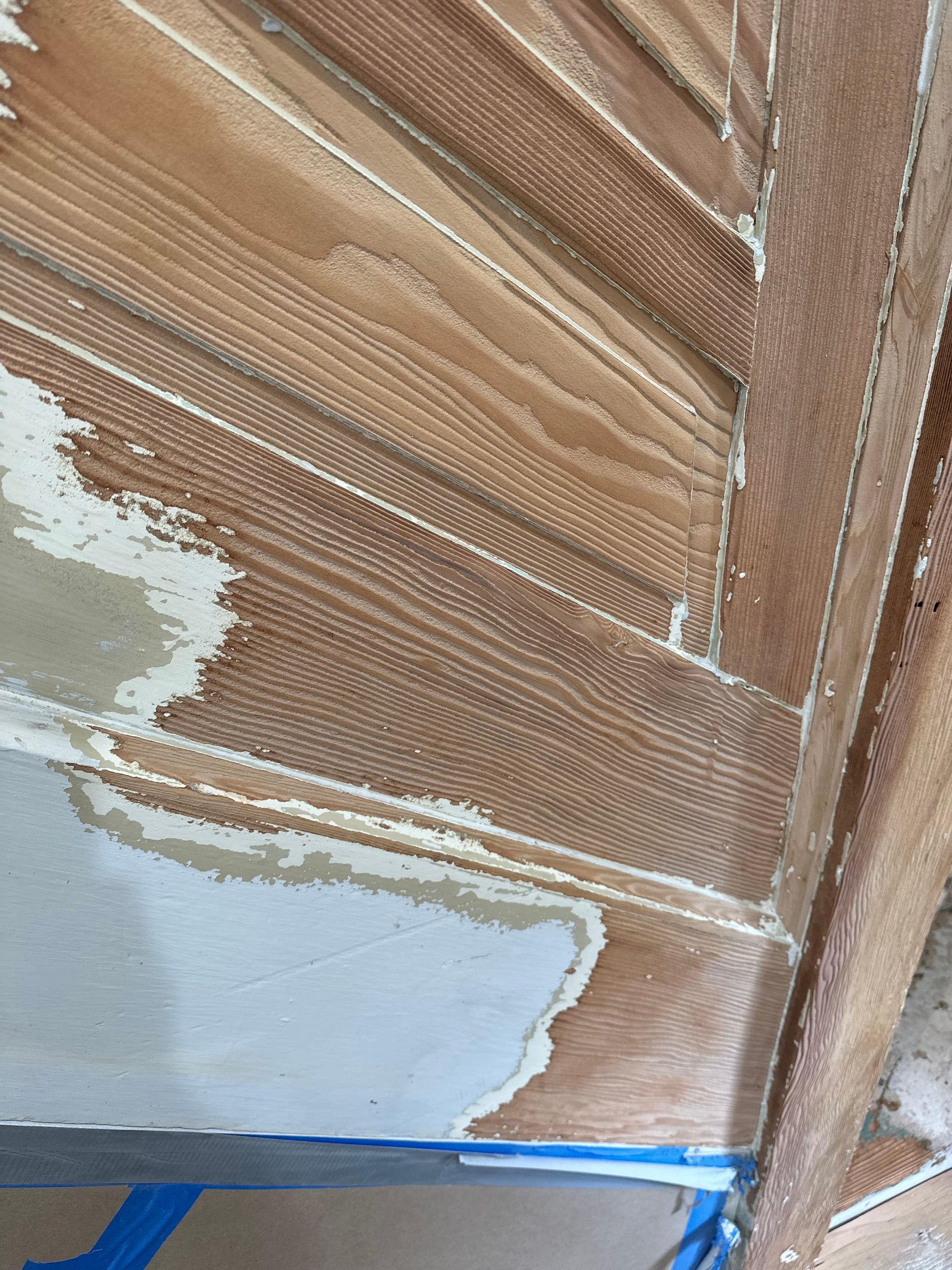 Wooden boat interior with exposed wood, showing paint application and repair.