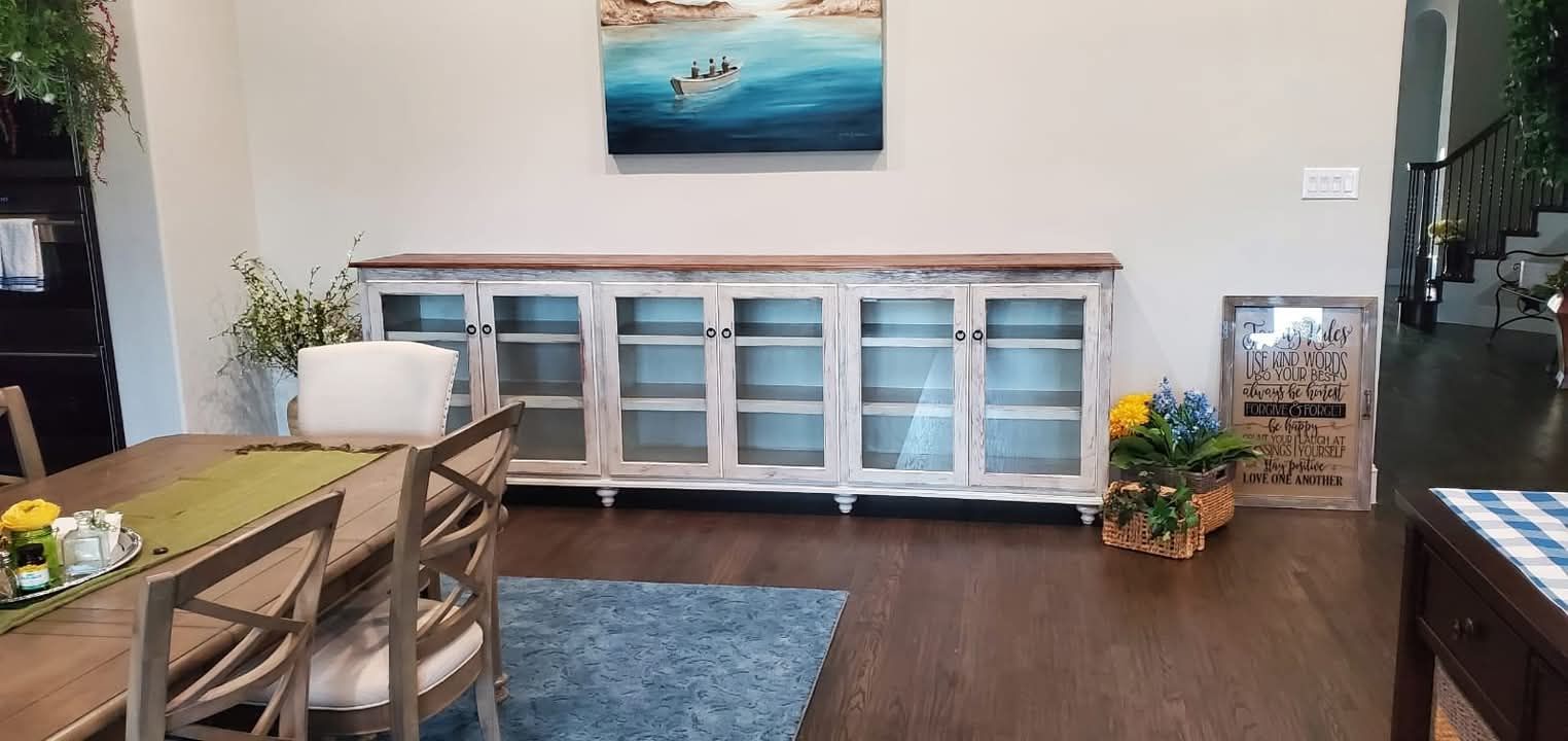 A dining room with a table and chairs and a painting on the wall