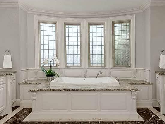A bathroom with a jacuzzi tub and three windows