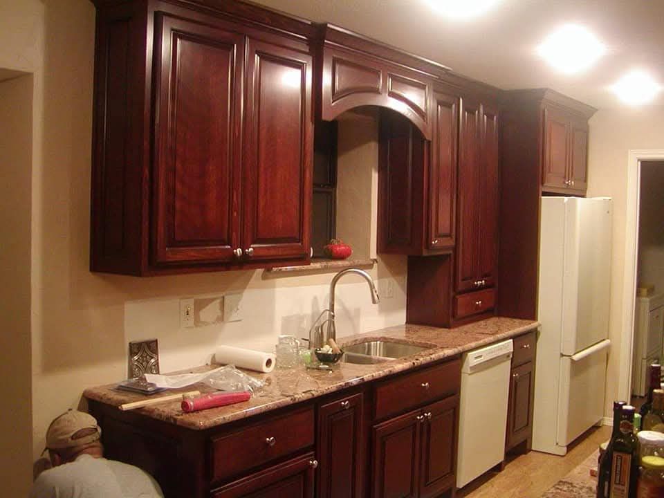 A kitchen with dark wood cabinets and granite counter tops